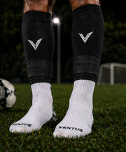 Black Core Pro-Cut Sleeves and Pro-Grip Socks worn on the pitch with a football