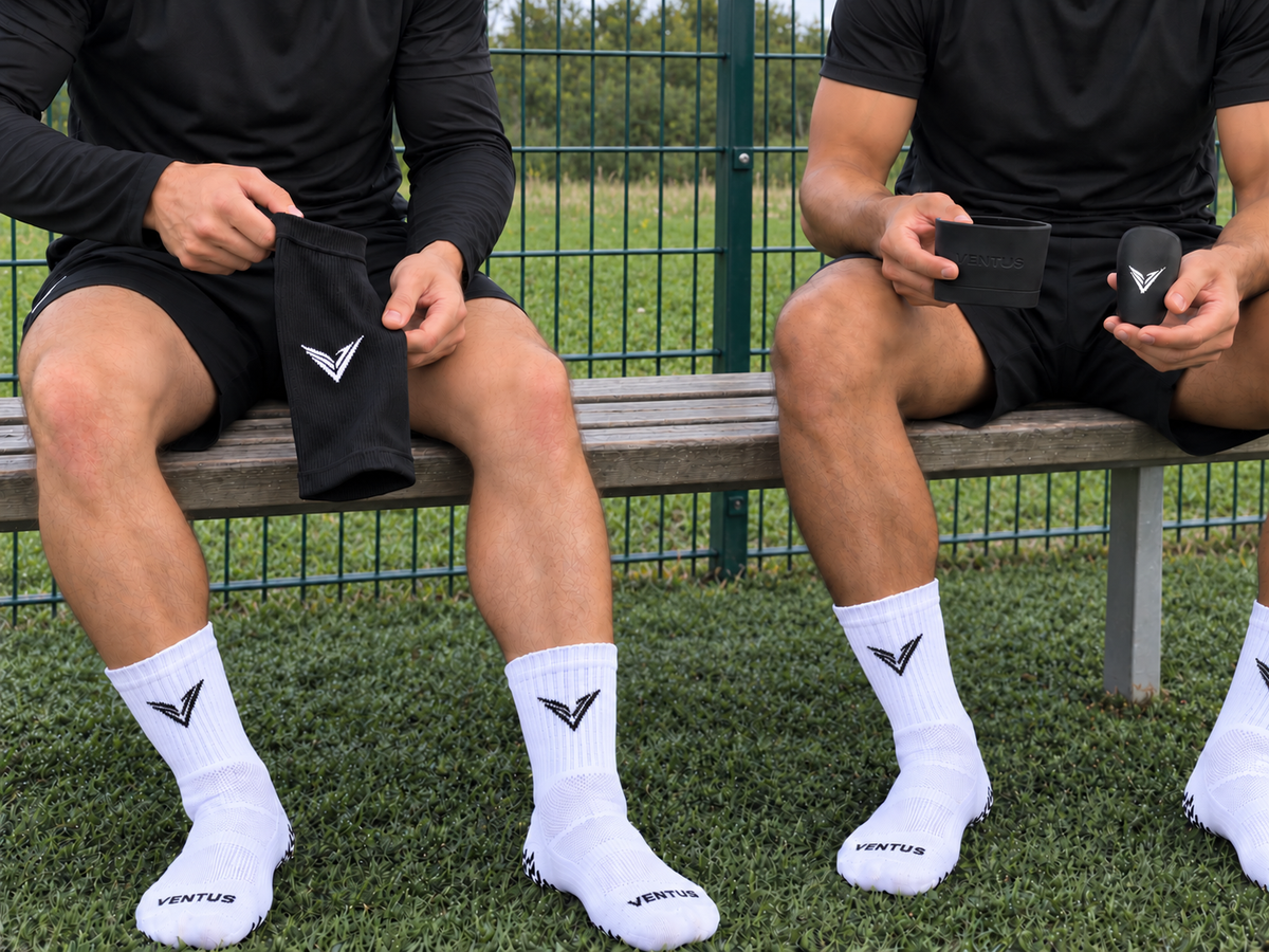The Ventus founders sitting on a pitchside bench in Pro-Grip Socks, holding black Pro-Cut Sleeves